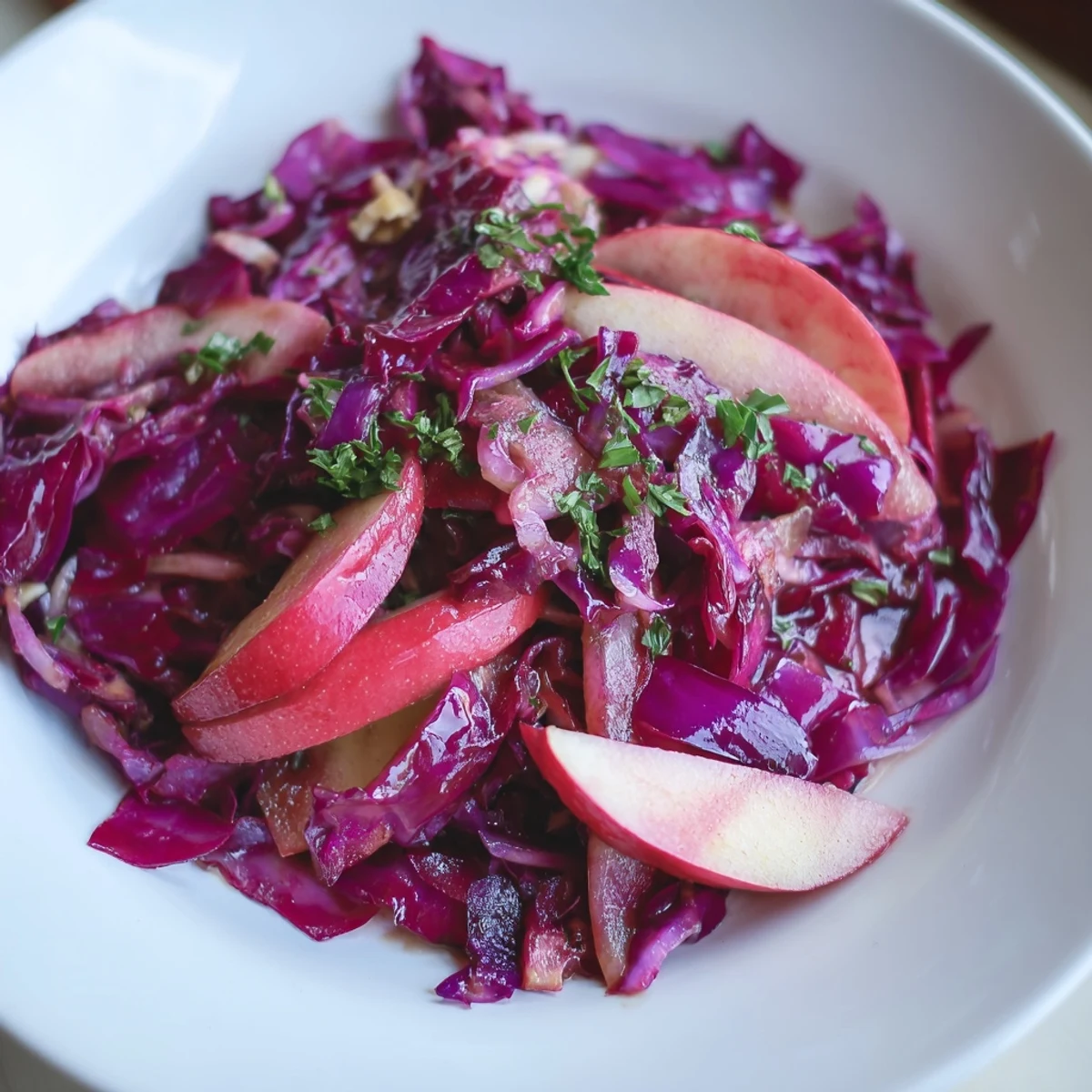 Lebendige Warm Red Cabbage Salad mit Äpfeln und warmem Dressing auf einem Teller.  